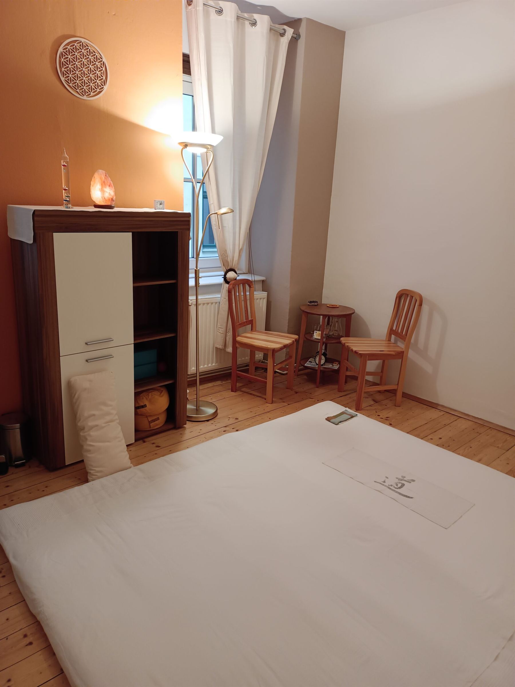 Behandlungsraum mit Futon, warmem Licht und Salzkristall-Lampe